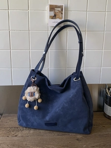 Navy blue faux suede tote bag with plush lamb charm and minimalist embossed logo