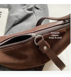Detail of smooth silver zipper and premium brown leather texture on a crossbody bag