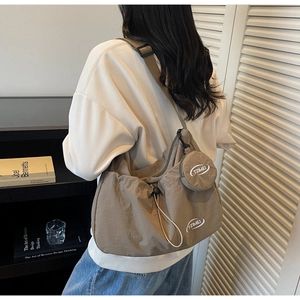 Dettaglio della borsa a tracolla in nylon kaki capiente con coulisse e mini pochette