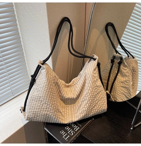 Close-up of beige checkerboard tote bag with yellow fashion embroidery and rope handle