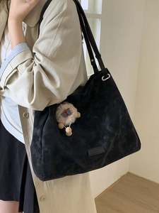 Retro black oversized suede tote bag with a cute sheep charm accessory shown on model