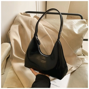 Détail d'un sac hobo noir avec texte embossé fashion et fermeture éclair argentée
