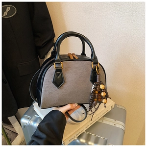 Detail of grey felt bowling bag with black leather trim and vintage gold hardware