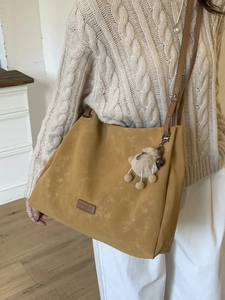 Chic mustard yellow oversized tote bag with plush charm and adjustable shoulder strap