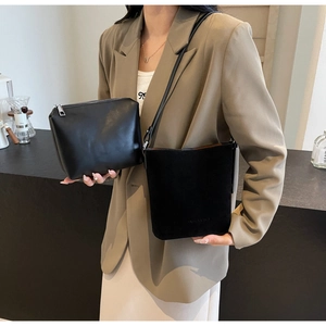 Detail view of black matte bucket bag and zipper pouch set with slim shoulder strap