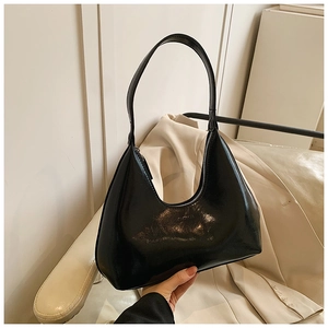 Gros plan du sac hobo en cuir noir semi-mat avec détail gaufré de texte mode