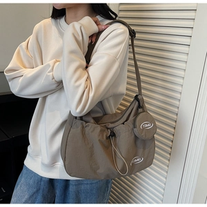 Borsa a tracolla in nylon marrone con tracolla regolabile e piccolo portamonete su modella