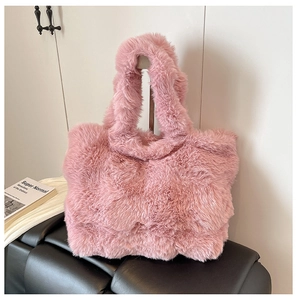 Detail of soft pink faux fur tote bag showing plush texture on a black leather bench