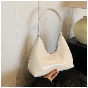 Détail du sac hobo en cuir verni blanc crème avec texte embossé et finition lisse brillante