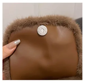 Detail van de magnetische sluiting op een bruine mini-rugzak van pluche en leer