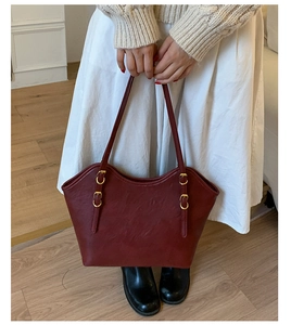 Detailansicht der dunkelroten Ledertasche mit goldener Metallschnalle und Trageriemen