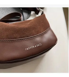 Detail of brown vintage dumpling bag showing the soft suede and leather texture stitching