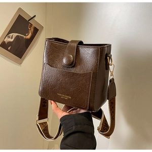 Détail du sac seau vintage café avec lettrage mode et une bandoulière classique large