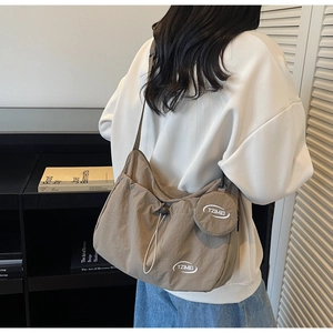 Dettaglio borsa a tracolla in nylon kaki con coulisse e mini borsellino rotondo coordinato