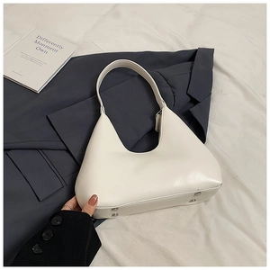 Détail du sac hobo en cuir blanc avec bandoulière intégrée et pieds de protection argentés