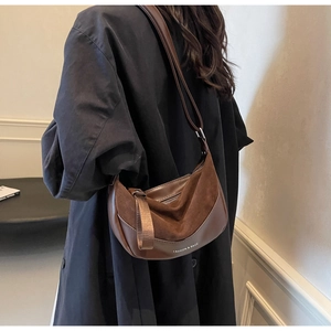 Detail view of brown vintage saddle bag featuring suede patchwork and fashion logo text