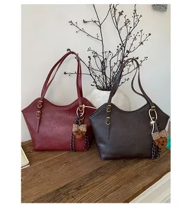 Details von Vintage-Plisseeleder-Taschen in Burgund und Braun mit Bärenanhängern