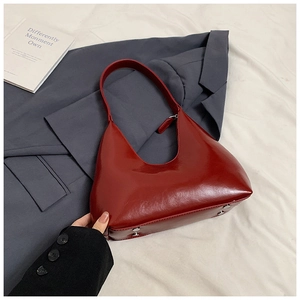 Détail du sac hobo en cuir rouge brillant avec rivets de protection argentés au fond