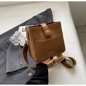 Détail du sac carré vintage en cuir marron avec large bandoulière jacquard et fermoir aimanté