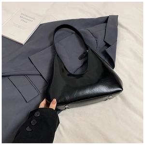 Vue détaillée du sac hobo en cuir verni noir avec des clous de protection en métal argenté