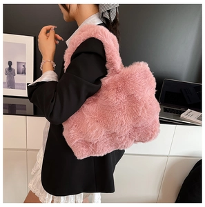 Detailed view of pink faux fur tote bag styled with a professional black blazer outfit