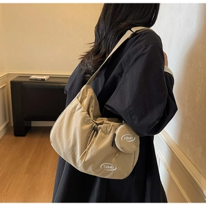 Dettaglio della borsa a tracolla in nylon beige con coulisse e mini borsellino rotondo