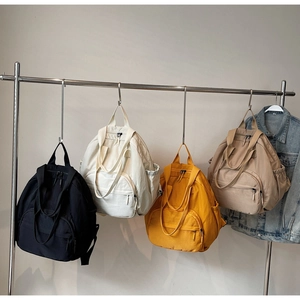 Detailed display of tote backpacks in black, cream, yellow and khaki nylon colors