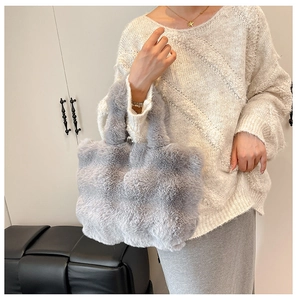 Detail of plush grey faux fur tote bag showing thick fluffy texture and dual handles