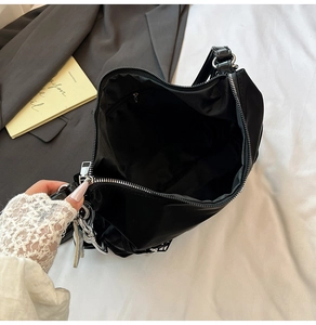 Macro view of spacious black tote bag interior with zipper pocket and metal hardware