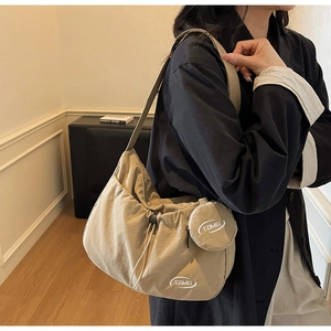 Dettaglio borsa a tracolla in nylon kaki con coulisse e piccolo portamonete rotondo