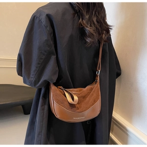 Detail view of retro brown suede crescent bag with Fashion & Bags text on model