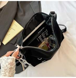 Detail showing the large interior capacity of this black minimalist bag with daily essentials