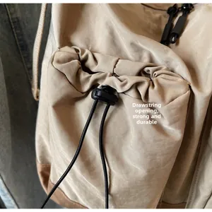 Dettaglio borsa in nylon con chiusura a coulisse e base in ecopelle resistente