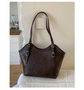 Detailansicht der braunen Leder-Shopper-Tasche mit verstellbaren Gold-Metallschnallen