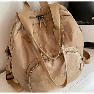 Detail showing high-capacity khaki nylon backpack with durable handles and side pockets