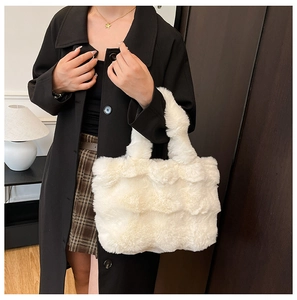 Detailed view of plush white faux fur tote bag styled with a black winter wool coat