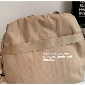 Close-up of khaki tote bag with back luggage strap fixed on suitcase handle