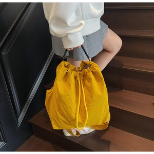 Macro di borsa a secchiello gialla con coulisse e manico intrecciato su scale di legno