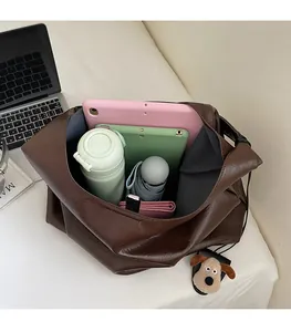 Top view of spacious deep brown tote bag interior filled with daily essentials