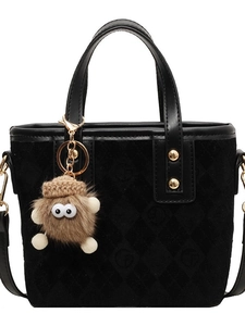 Black vintage suede bucket bag with quilted logo pattern and plush monster charm