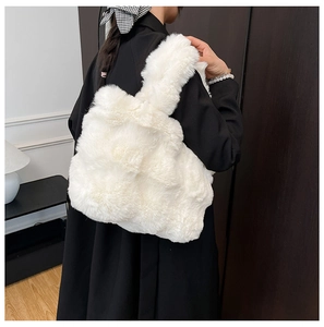 Detail of a white fluffy faux fur tote bag shown against a black coat for contrast