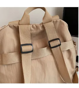 Detail showing wide adjustable shoulder straps and durable nylon fabric of the khaki backpack