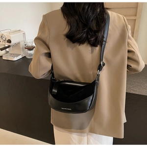 Detail of vintage matte black crescent saddle bag with adjustable strap and silver zipper