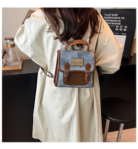 Rear view of a model wearing a vintage denim and brown leather patchwork backpack over a coat