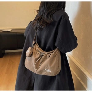 Dettaglio della grande borsa hobo in tela kaki con coulisse e piccolo portamonete tondo