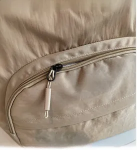 Detail shot of smooth metal zipper and nylon cord puller on khaki tote bag fabric