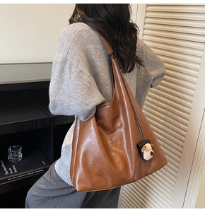 Brown vintage faux leather tote bag with a cute puppy plush charm for daily commuting