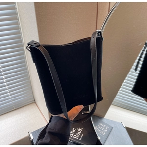 Detail of black matte suede bucket bag with FASHION & BAGS logo and leather strap