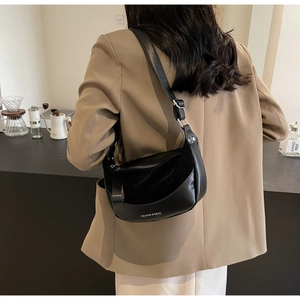Detail of black leather and suede half-moon bag with adjustable shoulder strap
