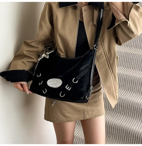 Detail view of black hobo bag with silver star pendant and metallic ring accents